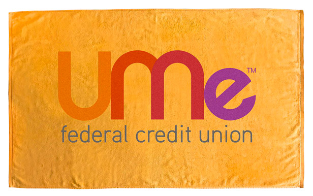 Orange velour beach towel with colorful logo in center