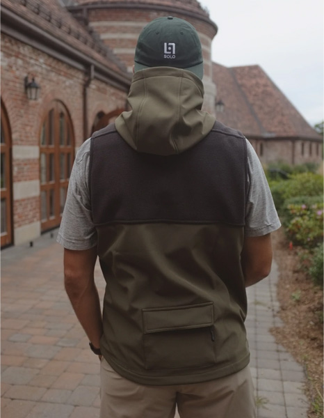 man wearing golf vest and hat, rear view