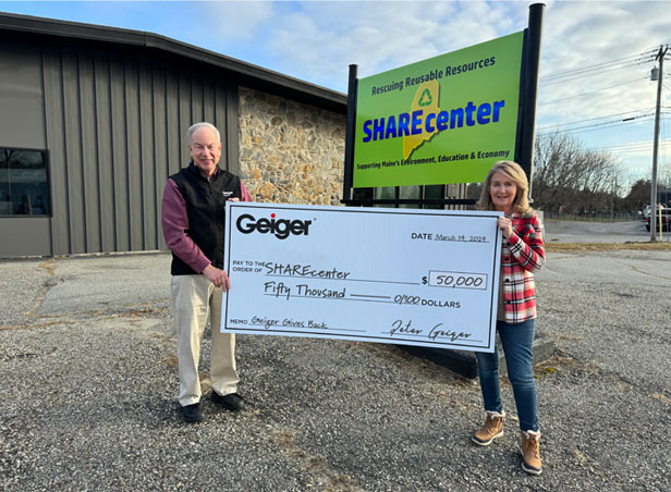 Peter Geiger and Lisa Rodrigues holding giant check